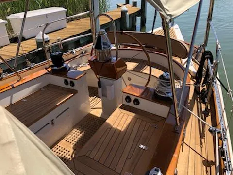 Slide: The Image of Cherubini Schooner 2000 with wooden deck, docked at a marina, showcasing elegant craftsmanship. - 8