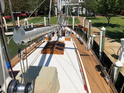 Slide: The Image of Cherubini Schooner 2000 docked, showcasing wooden deck and rigging in a serene marina setting. - 9