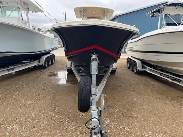 Slide: The Image of 2007 Scout 262 CC boat on trailer, parked between two other boats. - 13