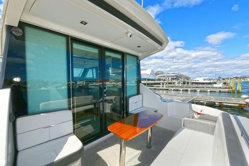 Slide: The Image of 2018 Tiara Yachts 39 Coupe with outdoor seating and table, docked at marina. - 10