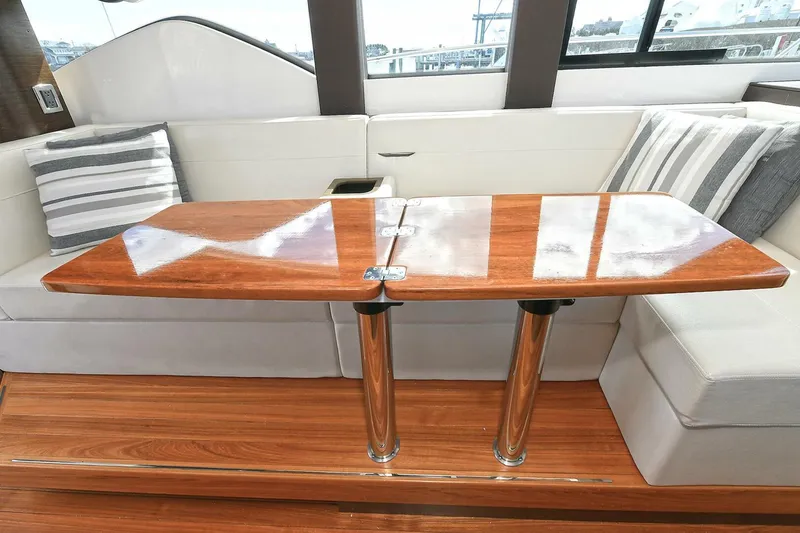 Slide: The Image of Interior of 2018 Tiara Yachts 39 Coupe with wooden table and cushioned seating. - 18
