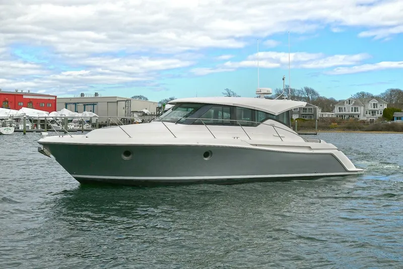Slide: The Image of 2018 Tiara Yachts 39 Coupe cruising on a calm waterway under a partly cloudy sky. - 2