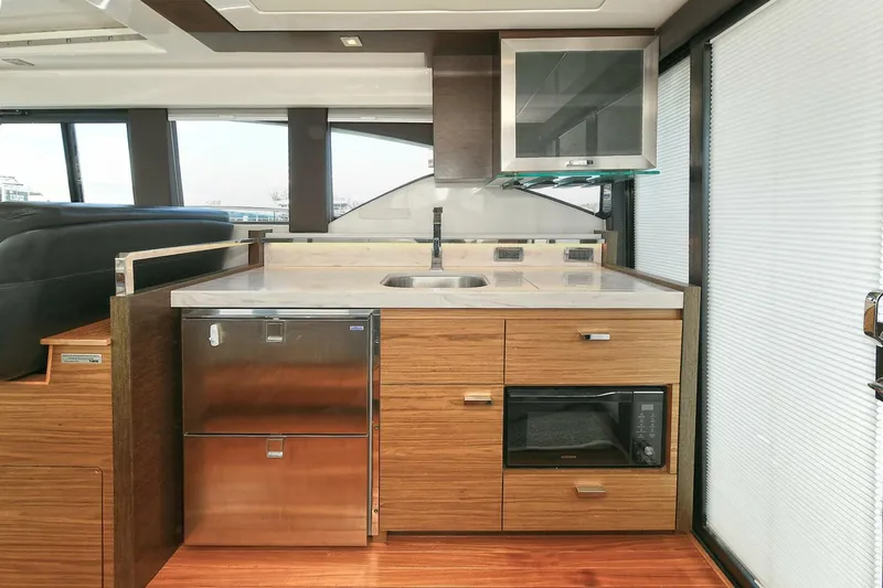 Slide: The Image of Modern kitchen in 2018 Tiara Yachts 39 Coupe with wood cabinetry and stainless steel appliances. - 25