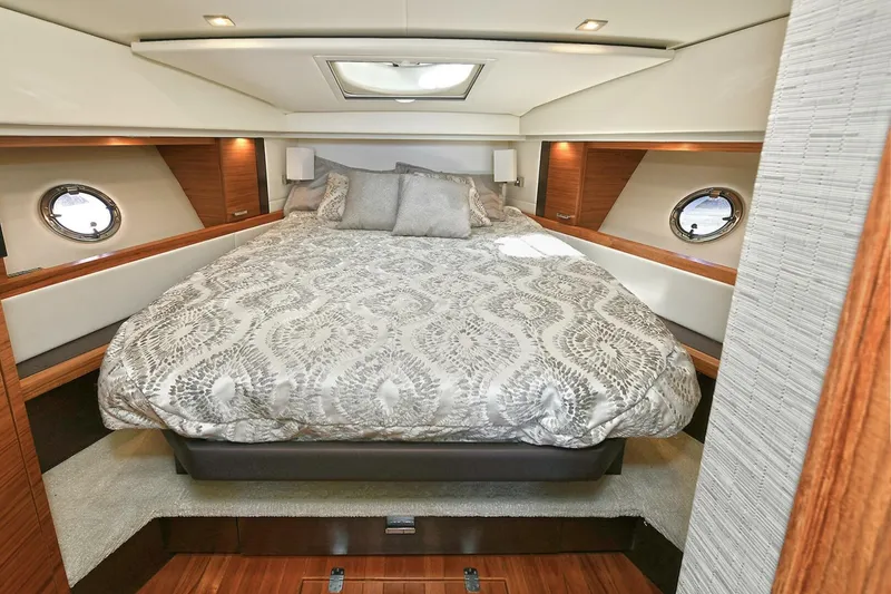 Slide: The Image of Luxurious bedroom interior of 2018 Tiara Yachts 39 Coupe with elegant bedding and porthole windows. - 33