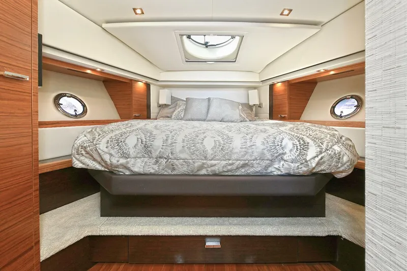 Slide: The Image of Luxurious bedroom interior of 2018 Tiara Yachts 39 Coupe with elegant bedding and porthole windows. - 34