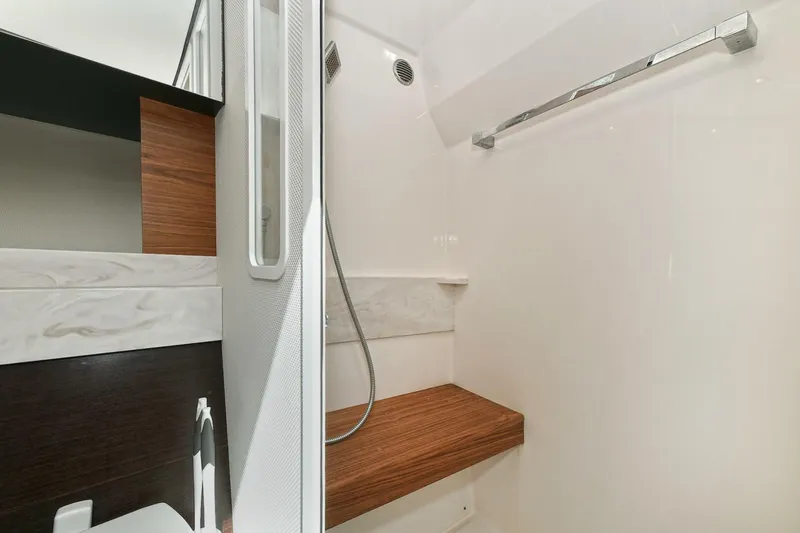 Slide: The Image of 2018 Tiara Yachts 39 Coupe bathroom with modern shower and wooden accents. - 39