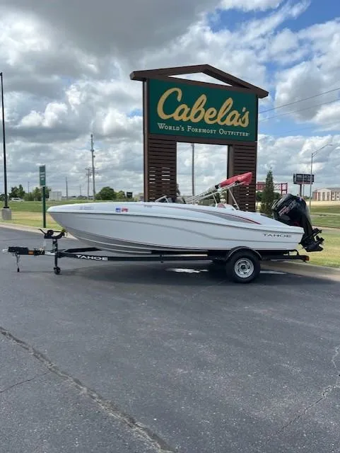 The Image of 2023 Tahoe T18 boat on trailer outside Cabela's store, under cloudy sky. - 0