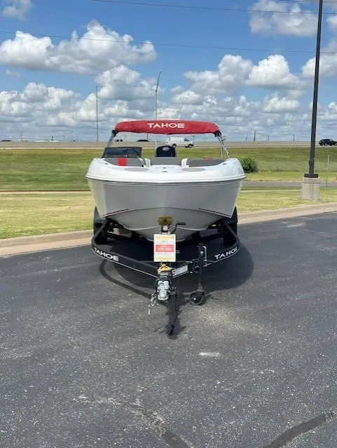 Slide: The Image of 2023 Tahoe T18 boat on trailer, parked outdoors under a cloudy sky. - 2