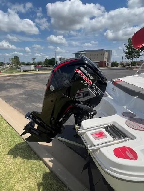 Slide: The Image of 2023 Tahoe T18 boat with powerful outboard motor, parked under a partly cloudy sky. - 9