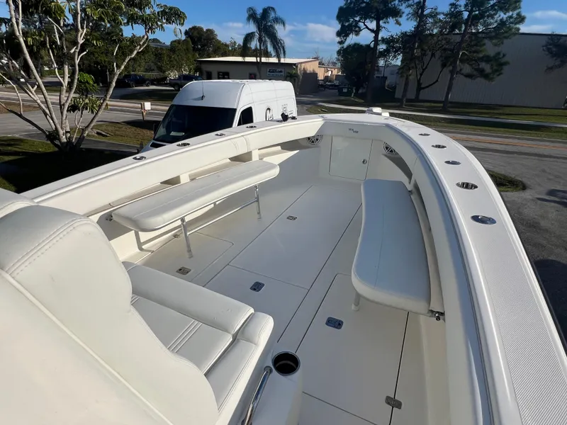 Slide: The Image of 2018 SeaVee 320B boat with spacious seating and sleek design, parked outdoors. - 13