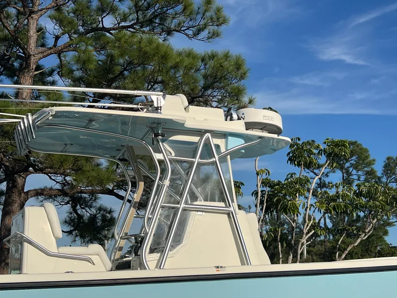 Slide: The Image of 2018 SeaVee 320B boat with T-top, set against a backdrop of trees and blue sky. - 17