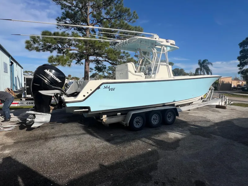 Slide: The Image of 2018 SeaVee 320B boat on trailer, light blue hull, parked outdoors. - 3