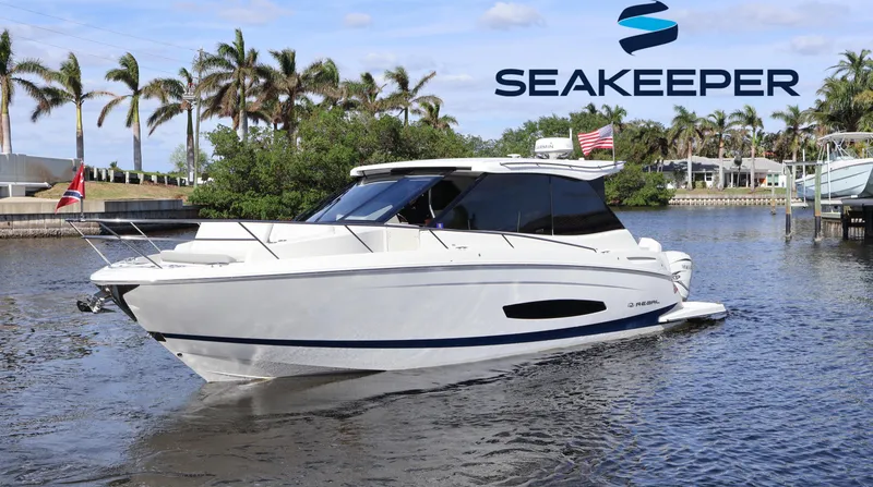 Slide: The Image of 2023 Regal 36 XO yacht on water, Seakeeper logo, palm trees in background. - 1