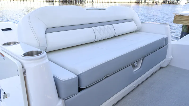 Slide: The Image of 2023 Regal 36 XO boat seating area with cup holders, overlooking water. - 14