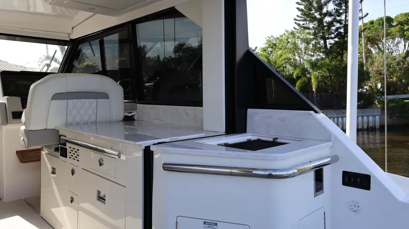 Slide: The Image of 2023 Regal 36 XO yacht interior with sleek kitchen and seating area. - 18