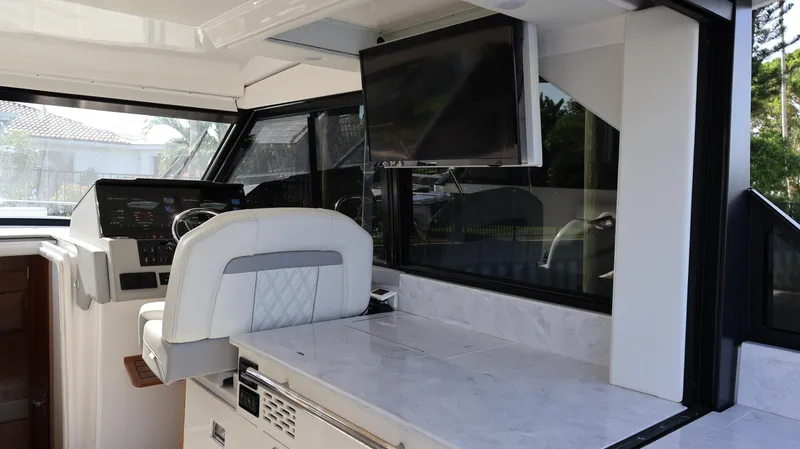 Slide: The Image of Interior of 2023 Regal 36 XO yacht with helm, marble counter, and mounted TV. - 21