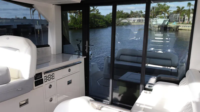 Slide: The Image of 2023 Regal 36 XO yacht interior with luxurious seating and waterfront view. - 28