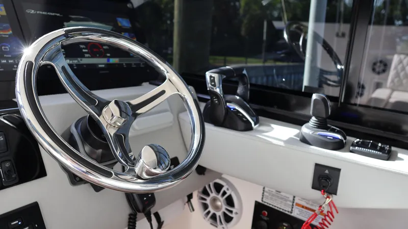 Slide: The Image of Steering wheel and controls of 2023 Regal 36 XO boat cockpit. - 33