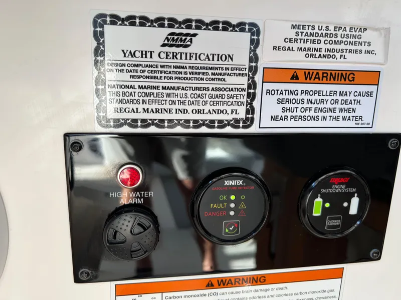 Slide: The Image of Control panel of a 2023 Regal 36 XO yacht with safety warnings and certifications. - 37