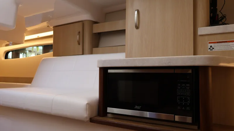 Slide: The Image of Interior of 2023 Regal 36 XO yacht featuring modern cabinetry and a built-in microwave. - 46