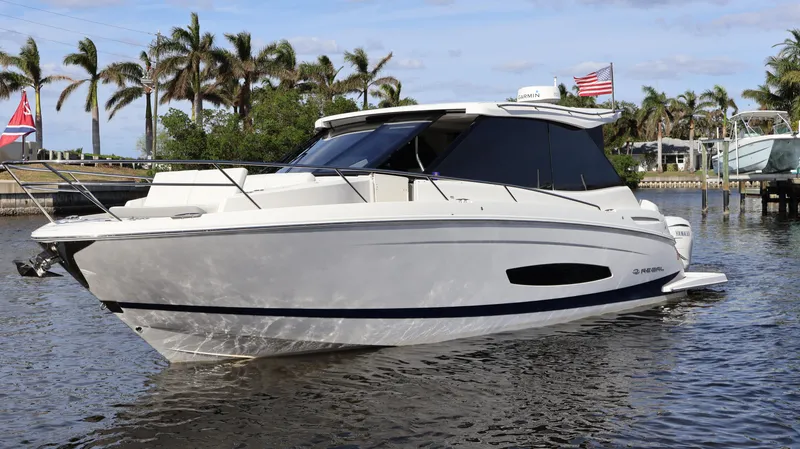 Slide: The Image of 2023 Regal 36 XO boat on water with palm trees in background. - 7