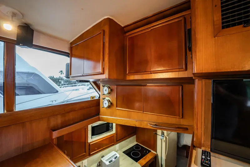 Slide: The Image of 1989 Post 43 Convertible yacht interior with wooden cabinets and modern appliances. - 12