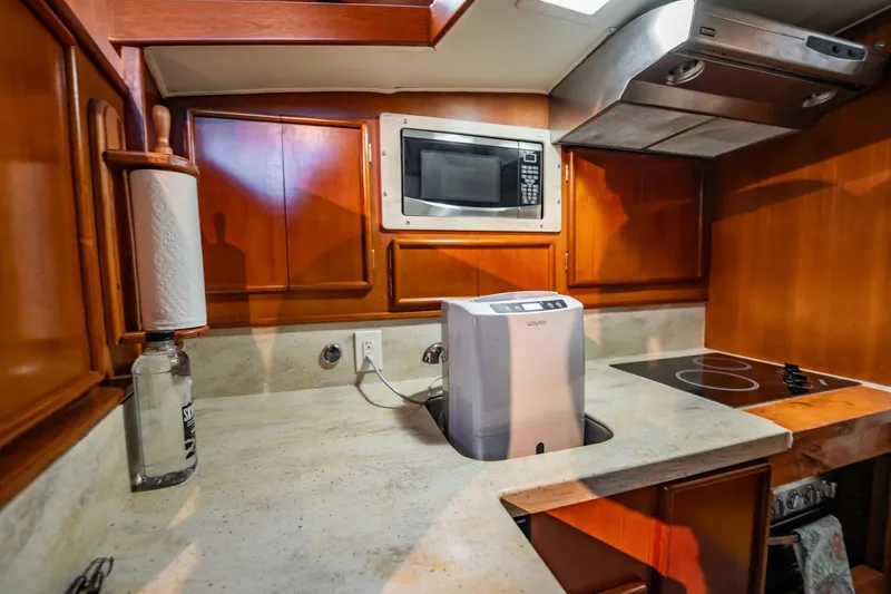 Slide: The Image of 1989 Post 43 Convertible kitchen with microwave, stove, and wooden cabinets. - 14