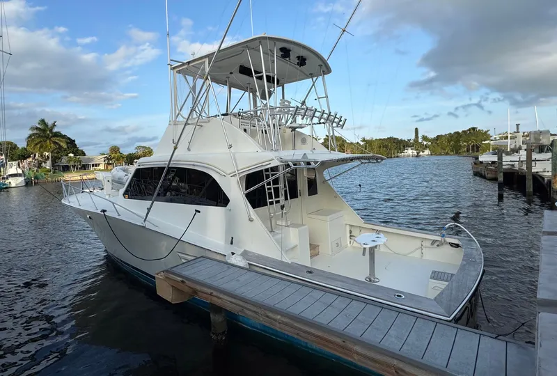 Slide: The Image of 1989 Post 43 Convertible yacht docked at marina, featuring spacious deck and flybridge. - 2