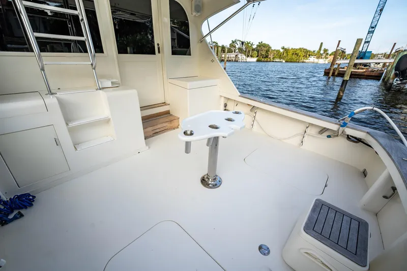 Slide: The Image of 1989 Post 43 Convertible yacht deck with fishing rod holders, docked by the water. - 23