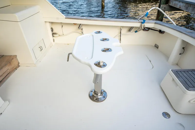 Slide: The Image of 1989 Post 43 Convertible boat deck with fishing rod holders, docked by the water. - 24