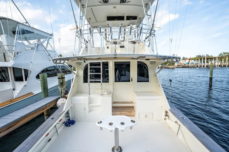 Slide: The Image of 1989 Post 43 Convertible yacht docked at marina, featuring spacious deck and fishing equipment. - 25