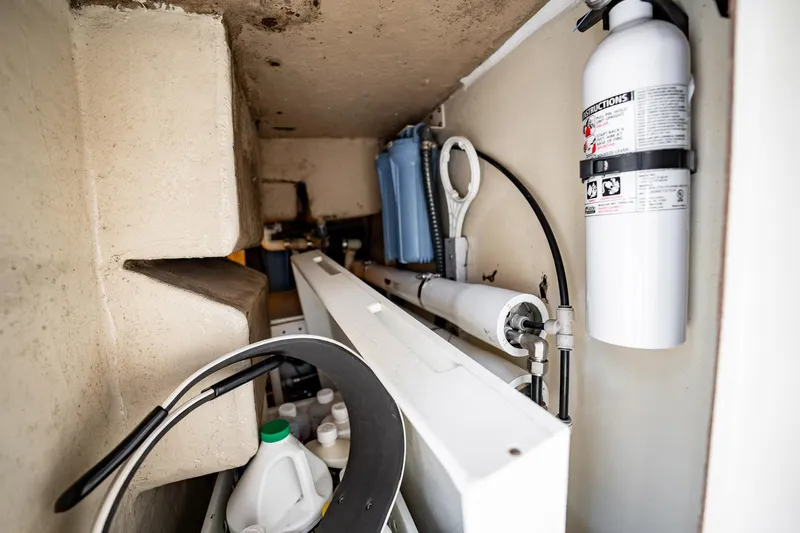 Slide: The Image of Storage compartment in a 1989 Post 43 Convertible boat with fire extinguisher and cleaning supplies. - 26