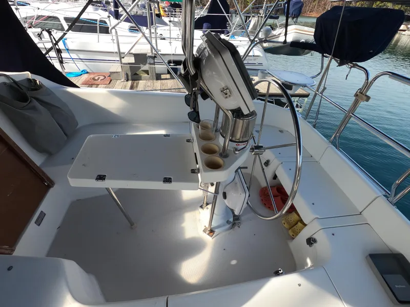 Slide: The Image of Cockpit of 2002 Catalina 310 sailboat with steering wheel and table setup. - 10