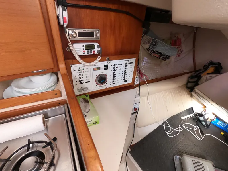 Slide: The Image of Interior of a 2002 Catalina 310 sailboat featuring navigation equipment and a compact kitchen area. - 13