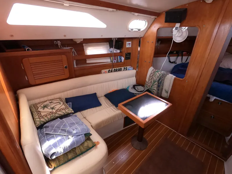 Slide: The Image of Interior of 2002 Catalina 310 sailboat with cozy seating and wooden finishes. - 17