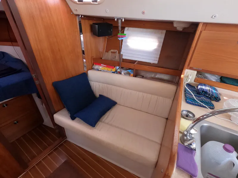 Slide: The Image of Interior of 2002 Catalina 310 sailboat with cozy seating and wooden cabinetry. - 18