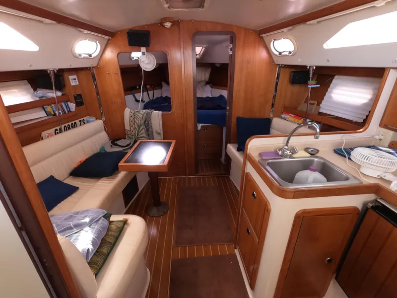 Slide: The Image of Interior of a 2002 Catalina 310 sailboat with cozy seating and compact kitchen area. - 19