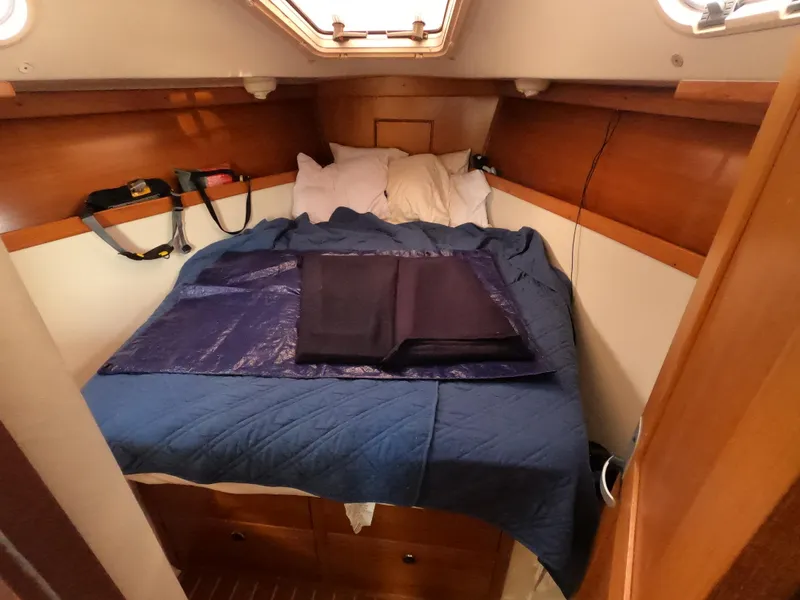 Slide: The Image of Cozy cabin interior of 2002 Catalina 310 sailboat with blue bedding and wooden accents. - 20