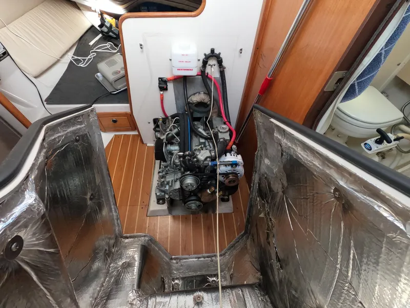 Slide: The Image of Engine compartment of a 2002 Catalina 310 sailboat, showcasing the engine and surrounding interior. - 24