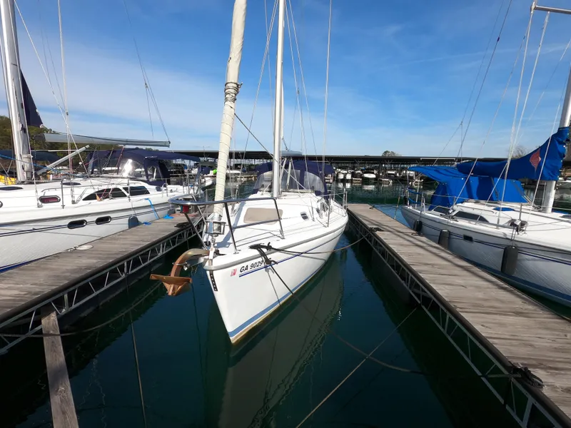 Slide: The Image of 2002 Catalina 310 sailboat docked at marina under clear blue sky. - 25