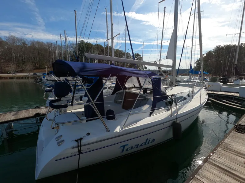 Slide: The Image of 2002 Catalina 310 sailboat docked at marina with blue canopy and clear sky. - 3