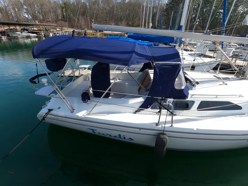 Slide: The Image of 2002 Catalina 310 sailboat with blue canopy docked in a marina. - 5