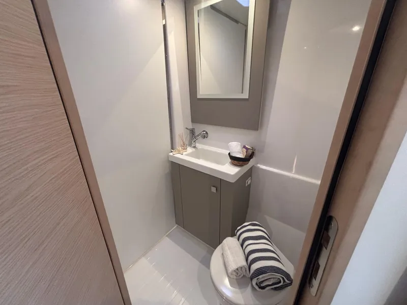 Slide: The Image of 2025 Fountaine Pajot Astrea 42 bathroom with modern sink, mirror, and neatly arranged towels. - 24