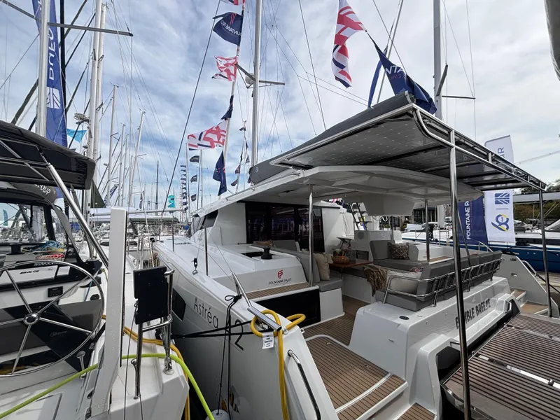 Slide: The Image of 2025 Fountaine Pajot Astrea 42 catamaran at a marina, showcasing sleek design and spacious deck. - 10