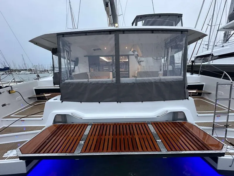 Slide: The Image of 2025 Fountaine Pajot Astrea 42 catamaran with open deck and illuminated boarding platform. - 16