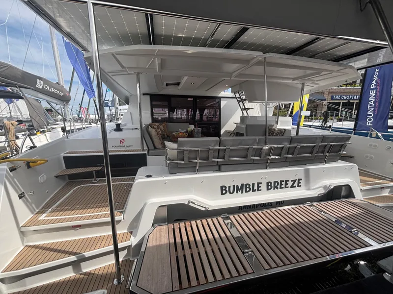 Slide: The Image of 2025 Fountaine Pajot Astrea 42 catamaran, "Bumble Breeze," docked with spacious deck and seating. - 4
