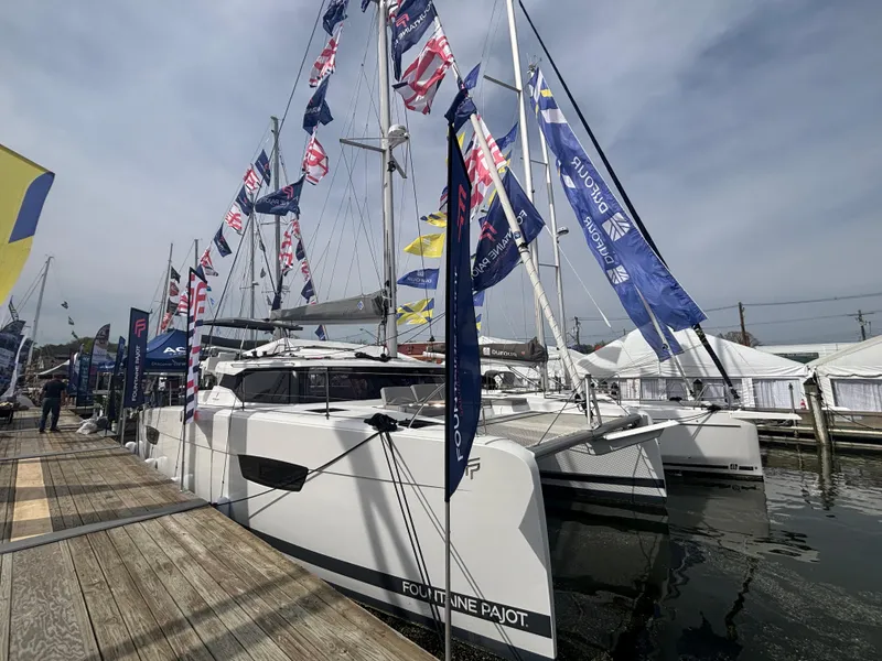 Slide: The Image of 2025 Fountaine Pajot Astrea 42 catamaran docked, adorned with colorful flags at a marina. - 40