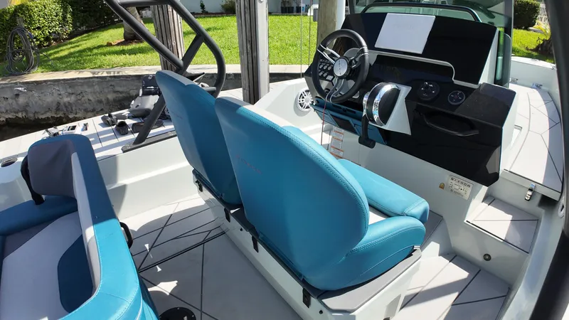 Slide: The Image of 2022 Saxdor SX200 boat interior with blue seats and modern steering console. - 11
