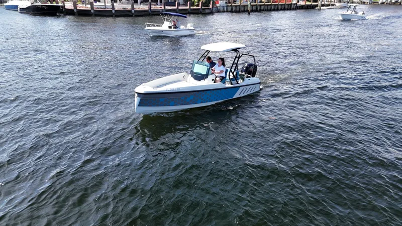 Slide: The Image of 2022 Saxdor SX200 boat cruising on a calm river with other boats nearby. - 2