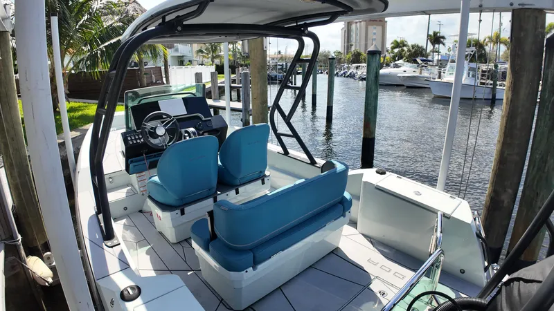 Slide: The Image of 2022 Saxdor SX200 boat interior with blue seats, docked at a marina. - 8